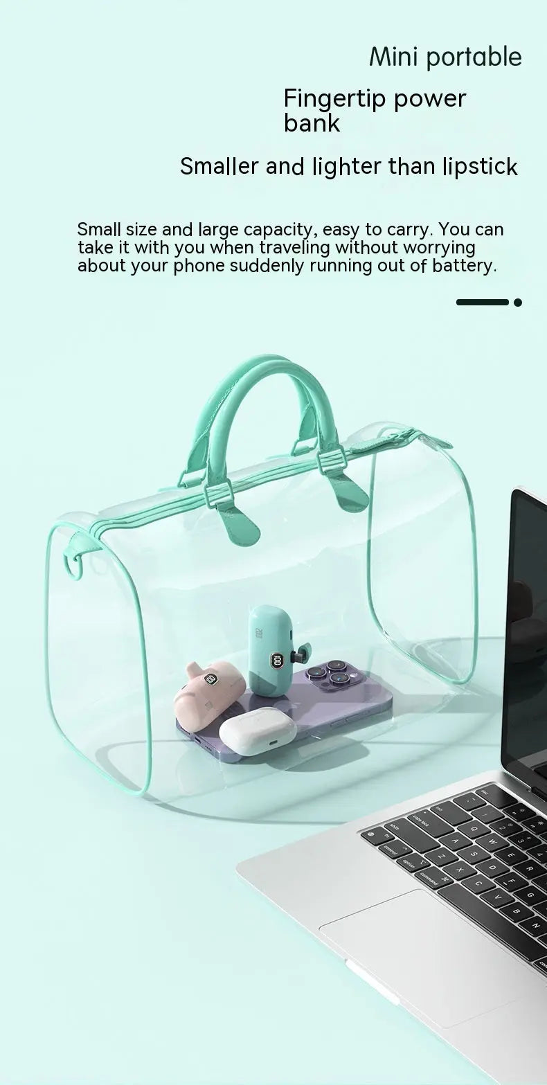 Mini portable power bank in a transparent bag next to a laptop, featuring fingertip design, and smaller than a lipstick for easy travel.